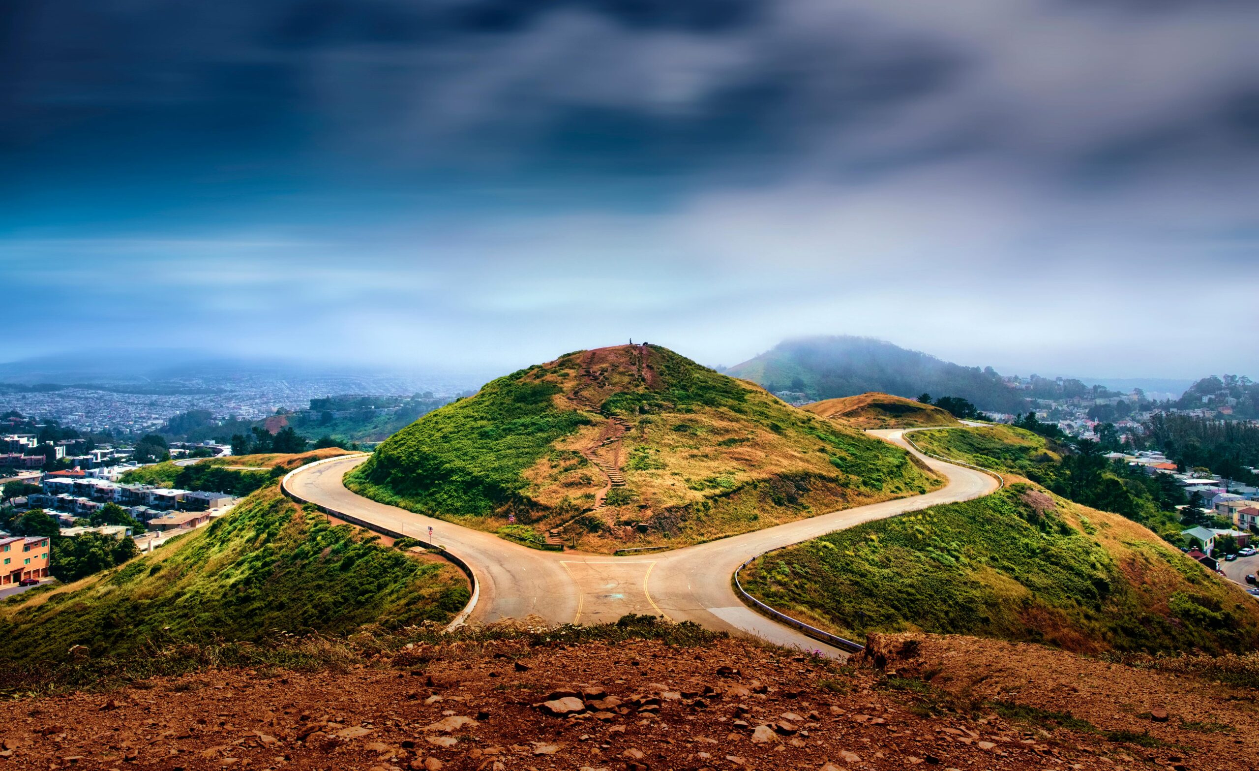 Breathtaking view of winding road at Twin Peaks overlooking San Francisco cityscape.